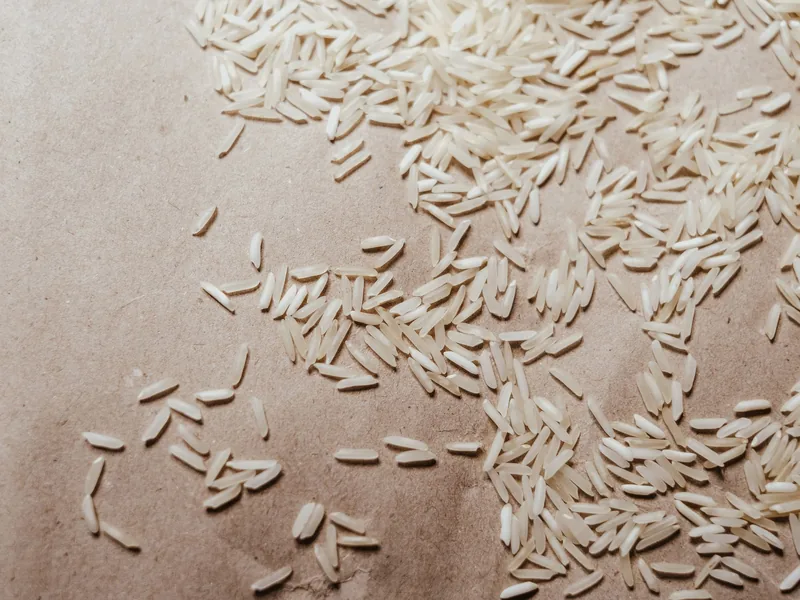 Long-grain basmati rice scattered on brown paper