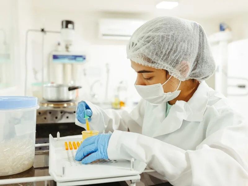 An analyst pipetting a prepared sample in a food laboratory